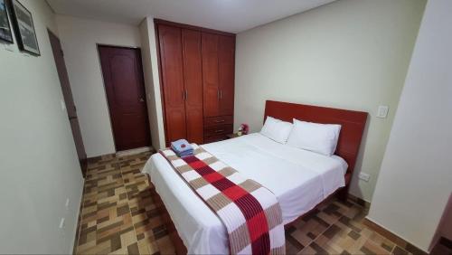 a bedroom with a bed with a plaid blanket on it at Edificio K&C in Sogamoso