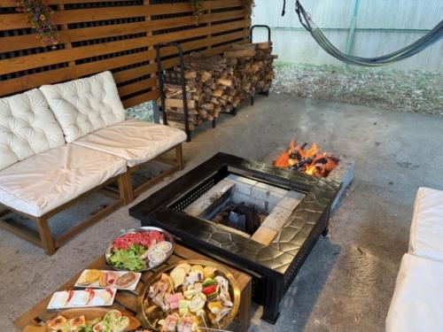 a fire pit with a bunch of food in front of it at グランコテージベンガルの森 in Nasu