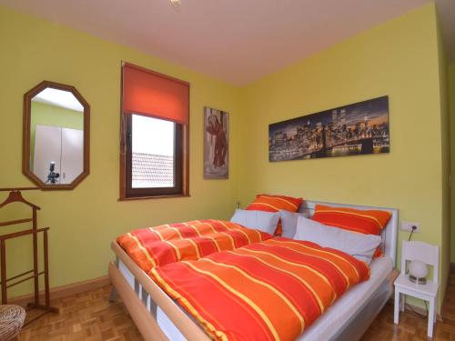 a bedroom with a bed with orange and yellow walls at Ferienwohnung im Erholungsort in Kurort Steinbach-Hallenberg