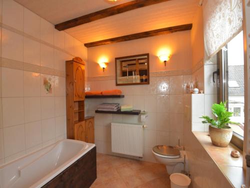 a bathroom with a tub and a toilet and a sink at Ferienwohnung im Erholungsort in Kurort Steinbach-Hallenberg