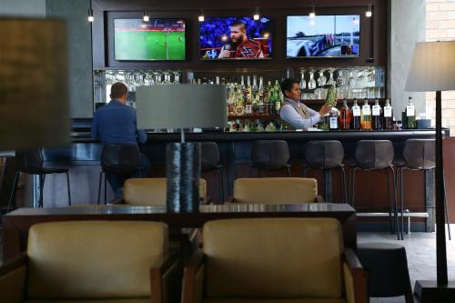 a bar with two men sitting at a bar at Casa Andina Select Tacna in Tacna
