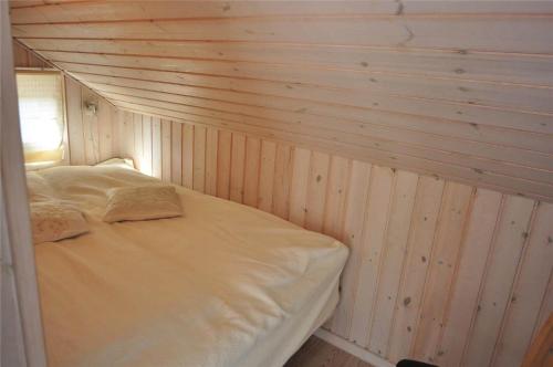 a bed in a room with a wooden wall at 30835-Ulfborg-Kornblomstvej-409 in Ulfborg