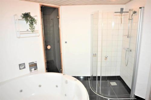 a bathroom with a bath tub and a shower at 30835-Ulfborg-Kornblomstvej-409 in Ulfborg