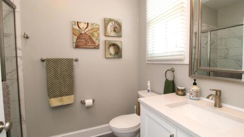 a bathroom with a toilet and a sink and a mirror at Breezes On Broad in Cape May