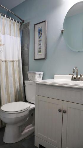 a bathroom with a toilet and a sink and a mirror at 103 Broadway The Broadway Breeze in Cape May