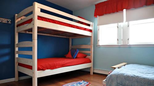 a bedroom with two bunk beds with a red bed at 103 Broadway The Broadway Breeze in Cape May