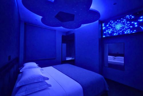 a blue bedroom with a bed and a blue ceiling at V Hotel in Arroyomolinos