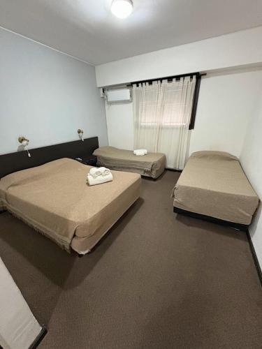 a room with two beds in a room at HOTEL APOLO NEUQUEN in Neuquén