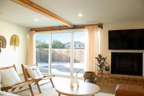 a living room with a fireplace and a large window at Sonoran Peach - Light-Filled 5BR near TMC in Tucson