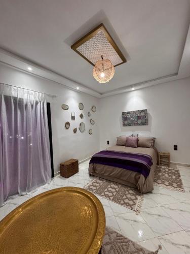 ein Schlafzimmer mit einem Bett und einem Tisch darin in der Unterkunft Dar Timi in Ech Chaïbat