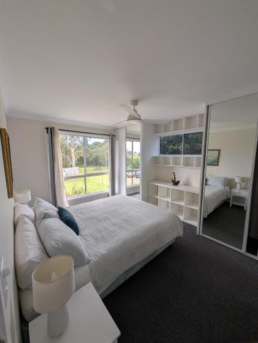 a bedroom with a large bed and a large window at Green Acres in Gympie in Monkland