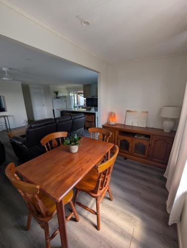 a living room with a wooden table and chairs at Green Acres in Gympie in Monkland