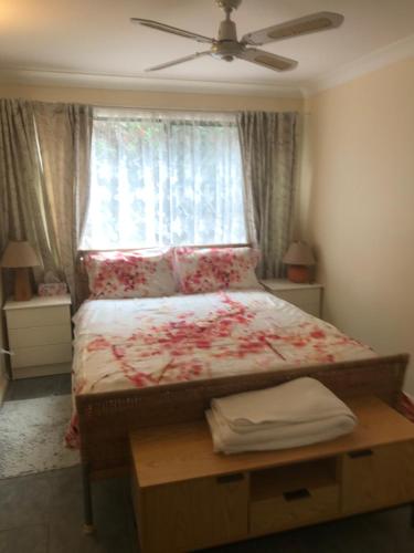 a bedroom with a bed with a window at The Mango Tree in Fingal Bay