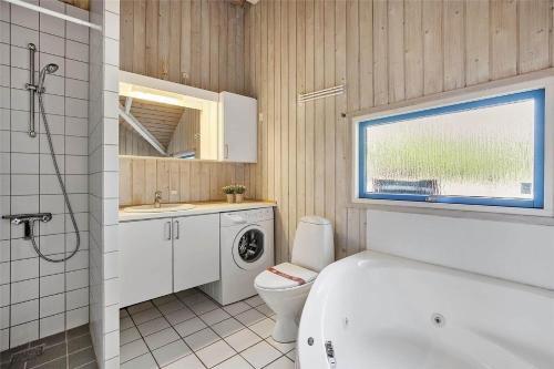 a bathroom with a toilet and a sink and a washing machine at SL117-Slagelse-Egebaekvej-6 in Slagelse