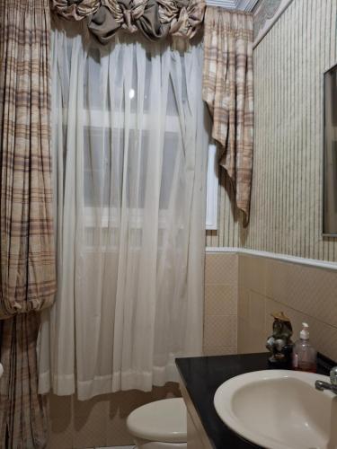 a bathroom with a sink and a toilet and a window at Chipipe Riviera del Mar in Salinas