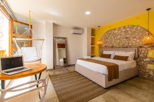 a bedroom with a bed and a laptop on a table at House with Private Pool & Rooftop in Cartagena de Indias