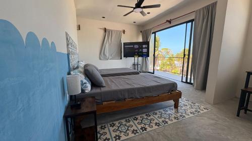 a bedroom with a bed and a large window at Casa Laura Penthouse in El Cuyo