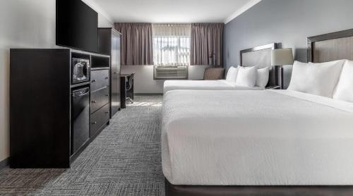 a hotel room with two beds and a television at Inn on Prince Hotel & Conference Centre, an Ascend Collection Hotel in Truro