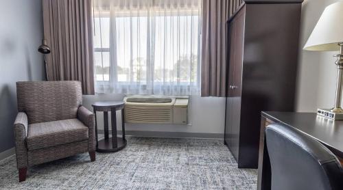 a room with a chair and a desk and a window at Inn on Prince Hotel & Conference Centre, an Ascend Collection Hotel in Truro