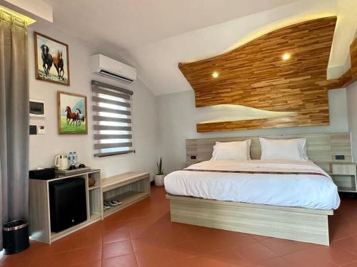 a bedroom with a bed and a flat screen tv at Oasis VangVieng Resort & Cafe in Ban Naka