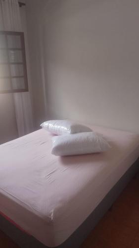 two white pillows sitting on top of a bed at Próximo ao centro de Mariana MG in Mariana