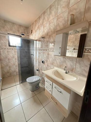 a bathroom with a toilet and a sink and a shower at Próximo ao centro de Mariana MG in Mariana