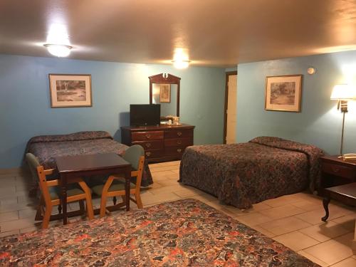 um quarto de hotel com duas camas e uma mesa em HWY Express Inn & Suites em Stillwater