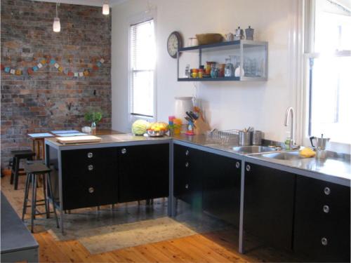 uma cozinha com um balcão preto e um lavatório em The Bank Guesthouse Glen Innes em Glen Innes