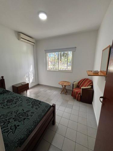 a bedroom with a bed and a couch and a window at Barrio La Victoria in Ezeiza