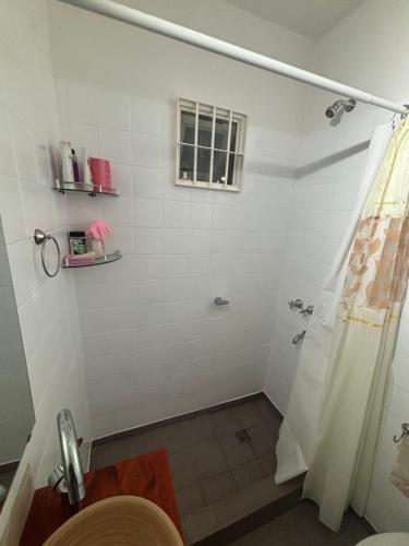 a bathroom with a shower with a toilet and a window at Barrio La Victoria in Ezeiza
