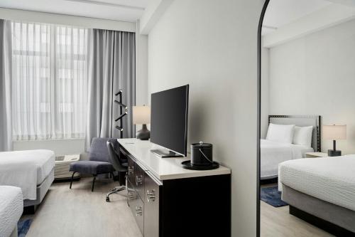 a hotel room with a desk with a computer and a bedroom at Fairfield Inn and Suites Chicago Downtown/ Magnificent Mile in Chicago