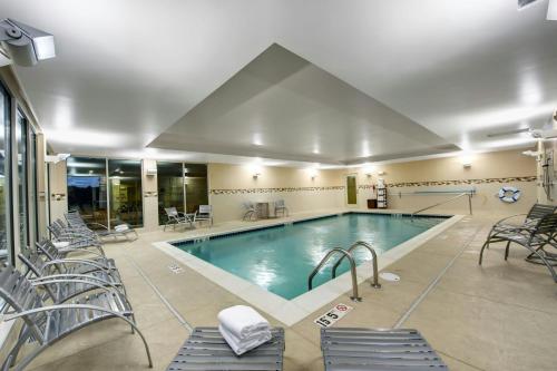 a pool in a hotel with chairs at TownePlace Suites by Marriott Providence North Kingstown in North Kingstown