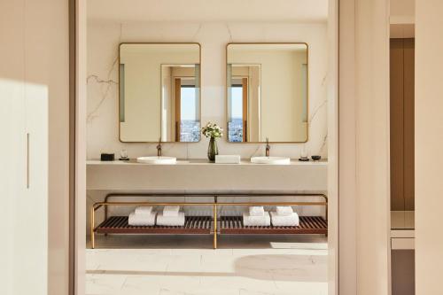 a bathroom with two sinks and two mirrors at Omni Boston Hotel at the Seaport in Boston