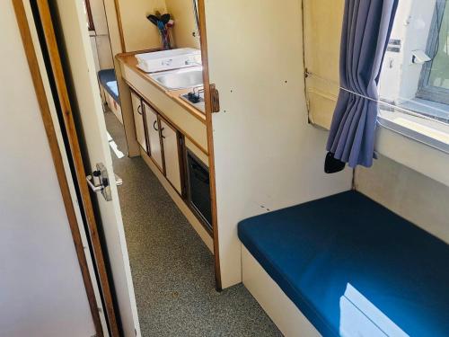 a small room with a blue bench next to a sink at Bateau sécurisé à quai - 6 pers. - API-1-46-30 in Colombiers