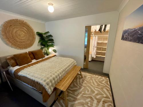 a bedroom with a bed and a hallway with a closet at White Rabbit Mountain Guest House in Mount Beauty
