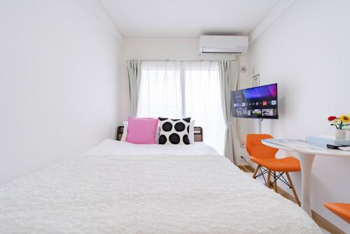 a bedroom with a white bed and a desk at アンドステイ屋形町704 in Kyoto