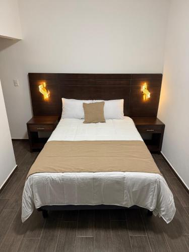 a bedroom with a large bed with two lights on it at Casa Legado in Orizaba