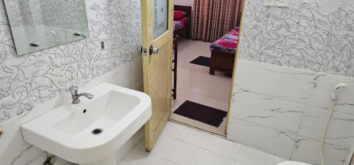 a bathroom with a white sink and a shower at Winter Palace Lakeside in Embilipitiya