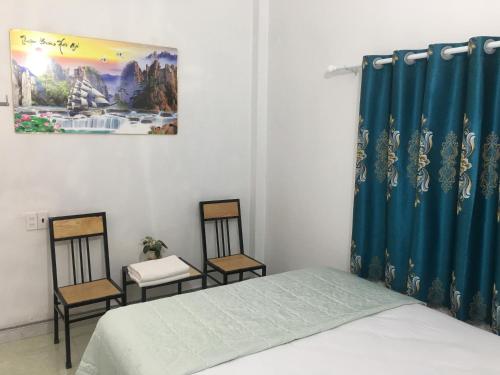 a bedroom with two chairs and a bed and a painting at Tam coc lotus lake homestay in Ninh Binh