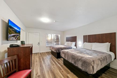 a hotel room with two beds and a red chair at Ambassador Lake Tahoe in South Lake Tahoe