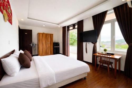 a bedroom with a bed and a desk and a television at Êm Villa 8 Bedrooms with Swimming Pool in Hue