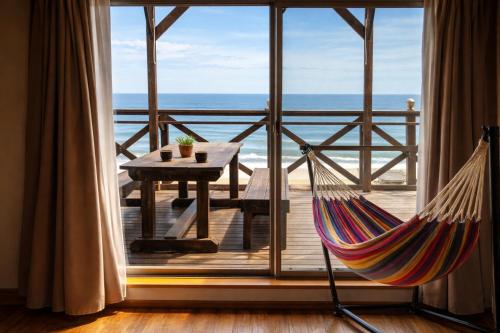 a hammock in a room with a view of the ocean at Aloha Beach Deck , Oceanfront, Stunning Sunrises, BBQ, Karaoke in Hokota