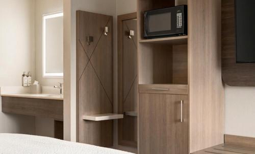 a bedroom with a bathroom with a tv and a bed at Holiday Inn Express - Bowling Green by IHG in Bowling Green