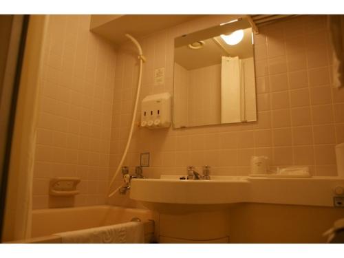 a bathroom with a sink and a mirror and a tub at Ichihara Marine Hotel - Vacation STAY 01289v in Ichihara