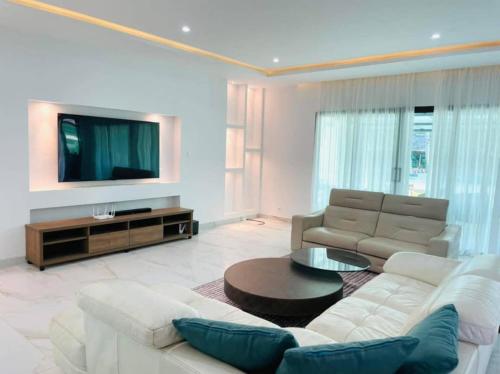 a living room with a white couch and a tv at villa zoum in Assinie
