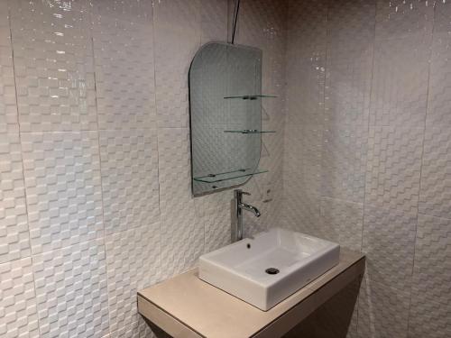 a white bathroom with a sink and a mirror at Villa lumbung sari in Cemagi