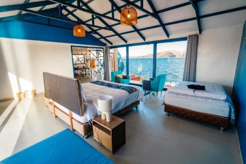 a bedroom with two beds and a view of the ocean at Uros Titicaca Lodge Puno in Puno