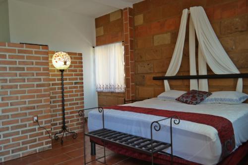 a bedroom with a bed and a brick wall at Wellness Pet Friendly El Secreto in Tepoztlán