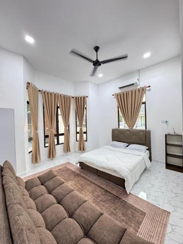 a bedroom with a large bed and a couch at NY VILLA Homestay in Kota Bharu