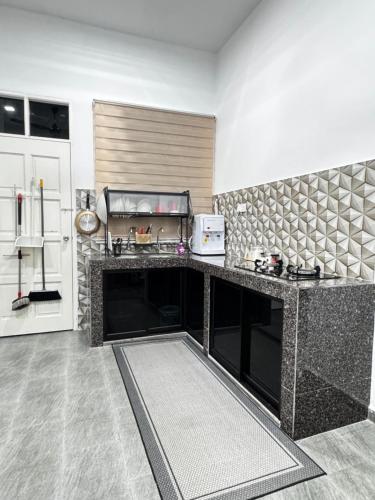 a kitchen with a counter and a refrigerator at NY VILLA Homestay in Kota Bharu